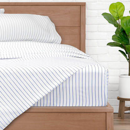 A bed made with pinstripe sheets