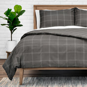 Duvet set on a bed with a plant in the background.