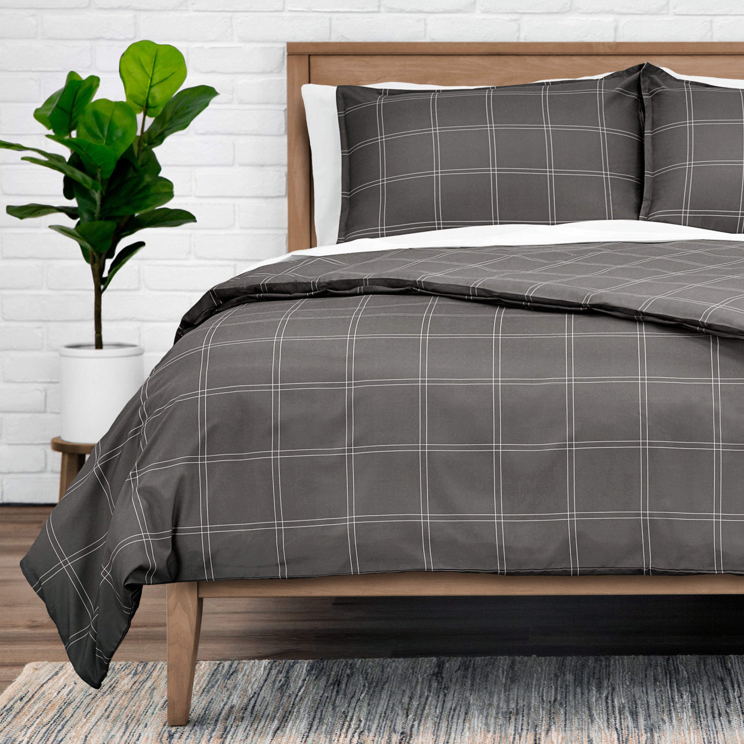 Duvet set on a bed with a plant in the background.