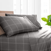Printed bed sheet set on a bed with a white background