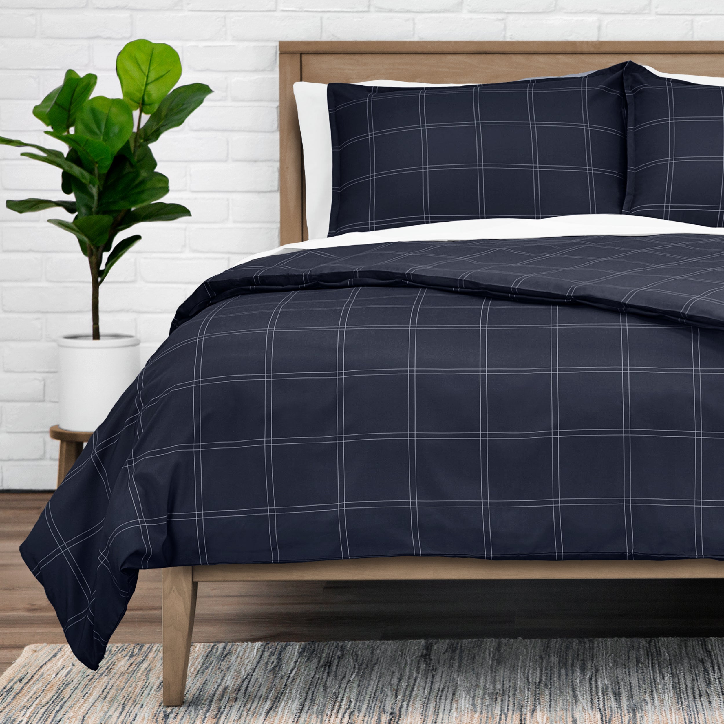 Duvet set on a bed with a plant in the background.