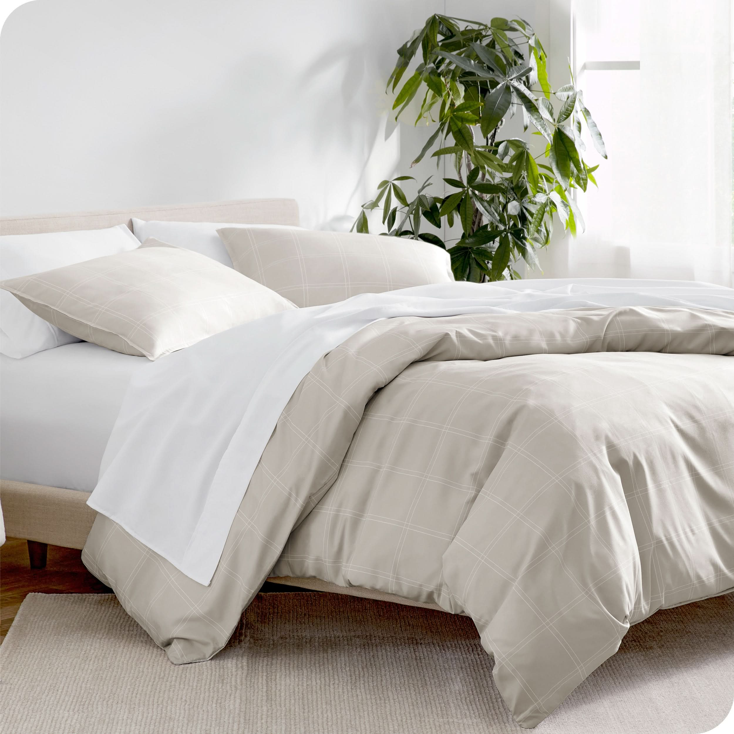 Angled view of bed showing a printed duvet cover draped over side of bed and included pillow shams