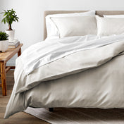 Duvet set on a bed with plants in the background.