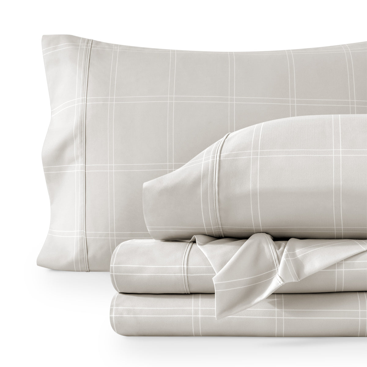 Set of gray checkered bedding including a pillow and two folded sheets on a white background