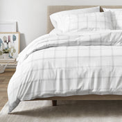 White and gray plaid duvet on a bed in a bedroom setting
