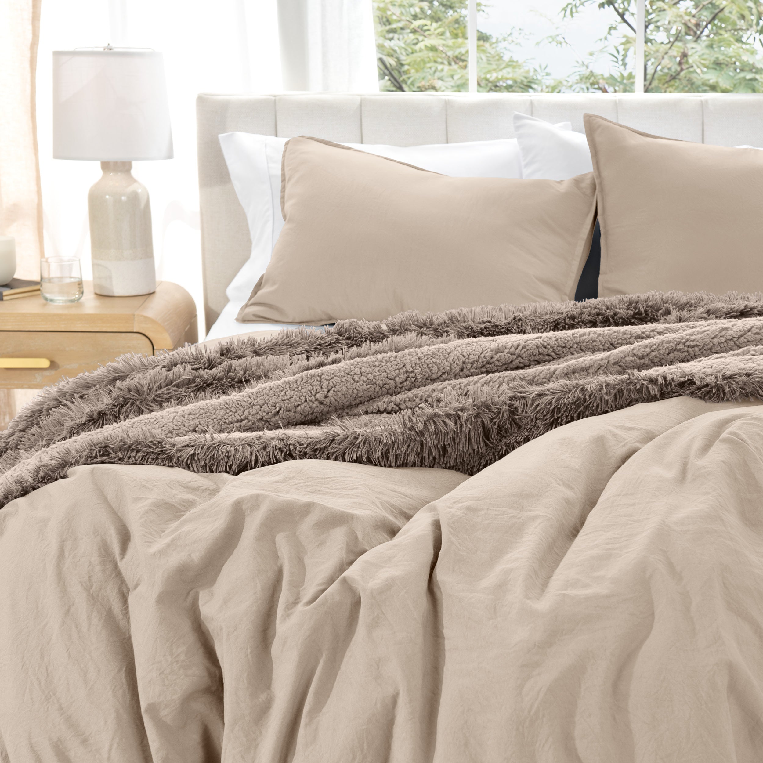 Washed duvet cover set on a bed with pillows and a lamp in the background