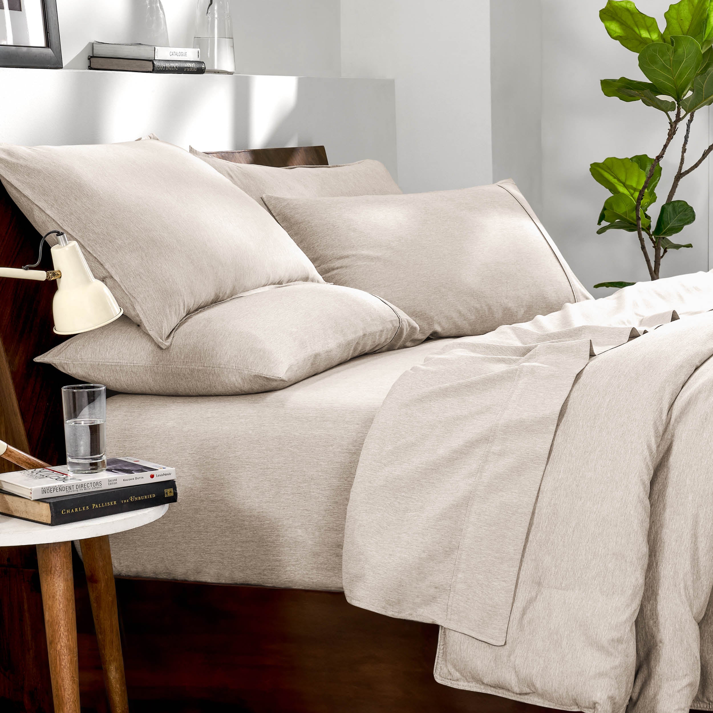 Bedding set on a bed in a bedroom with a side table and lamp.