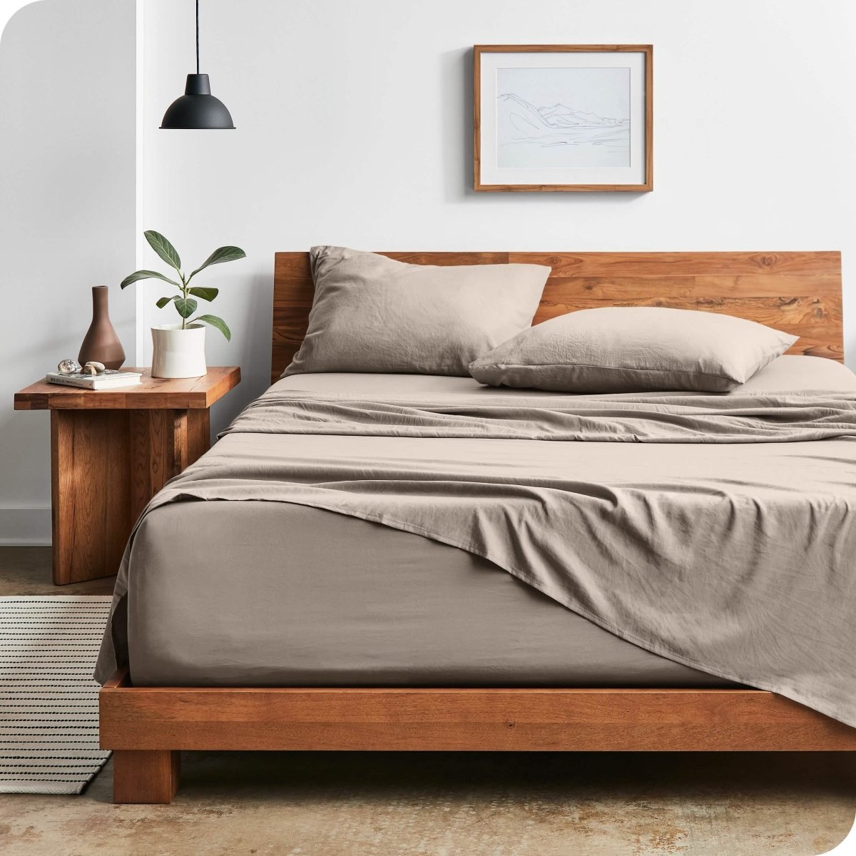 Modern bedroom with washed sheets draped over the end and the side of the bed
