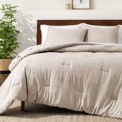 Bedding set on a bed in a bedroom with a side table and lamp.
