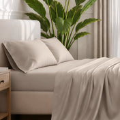 Ultra-soft sheets and pillowcases on a bed with a plant in the background