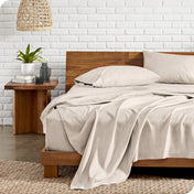 Bed with microfiber bedding against a white brick wall.