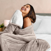A woman smiling while wrapped in a sherpa blanket