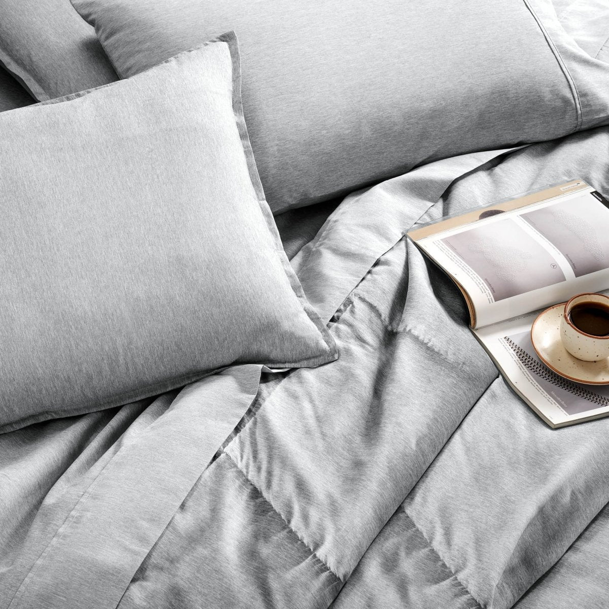 Bedding set with an open book and a cup on a saucer.
