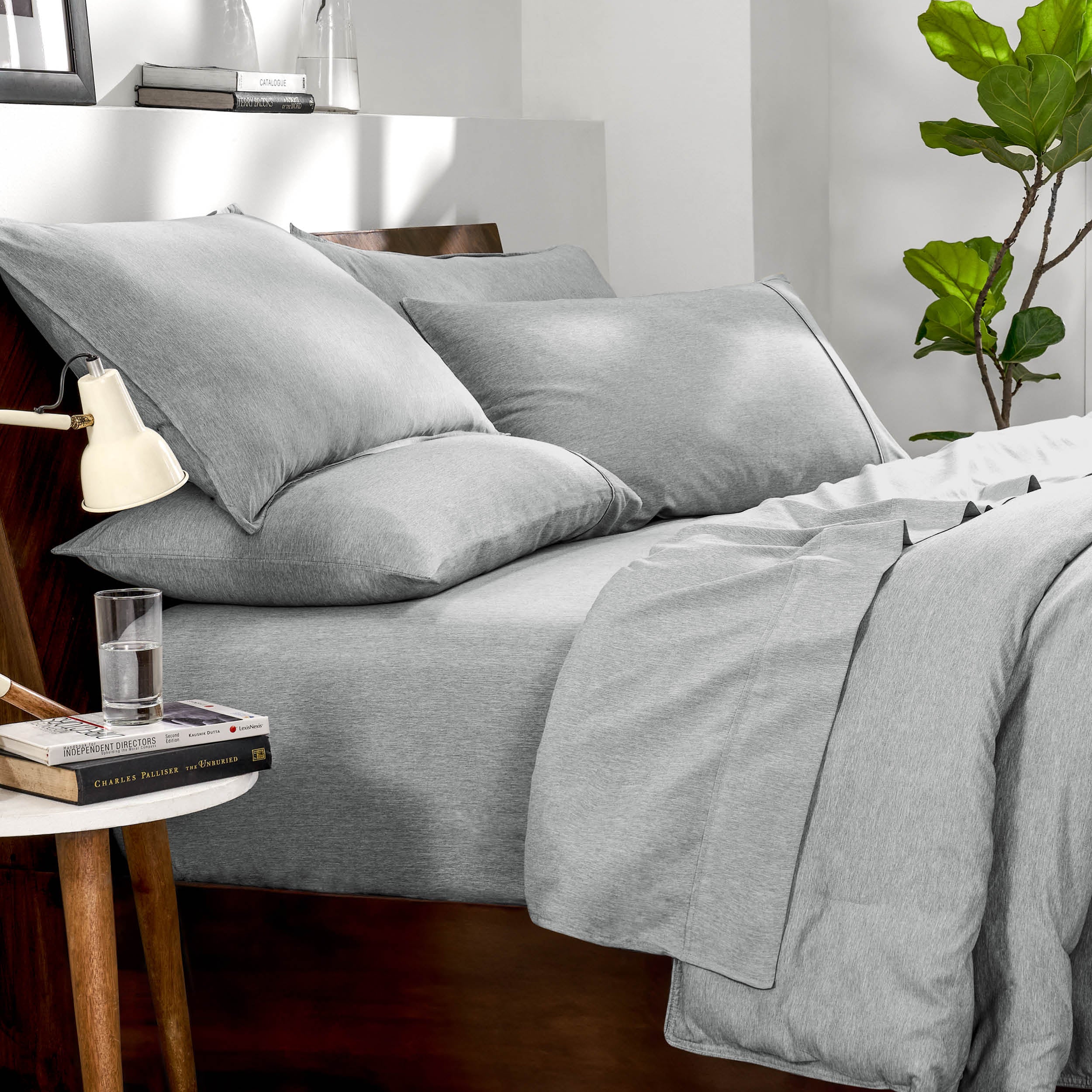 Bedding set on a bed in a bedroom with a side table and lamp.