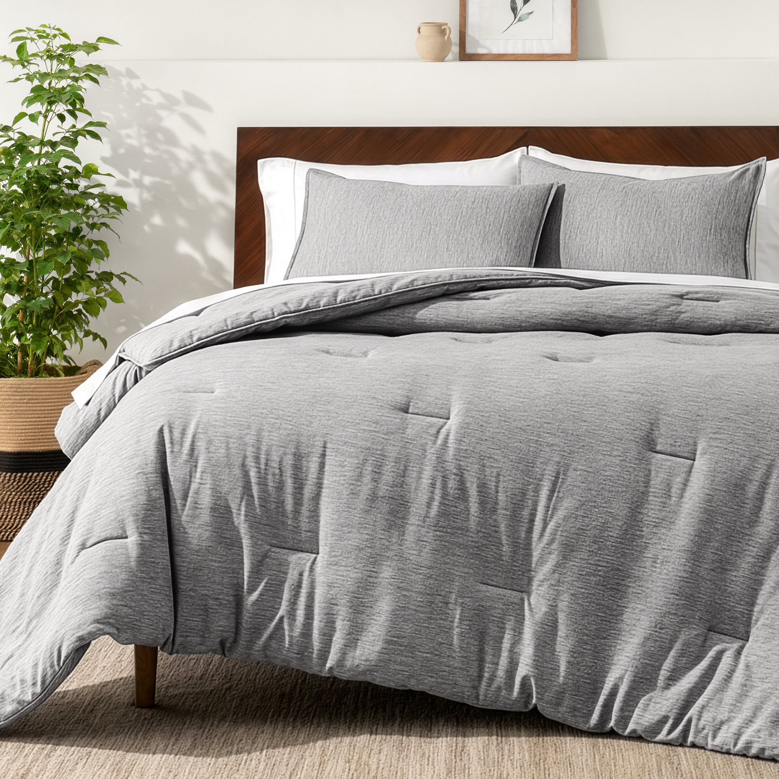 Bedding set on a bed in a bedroom with a side table and lamp.