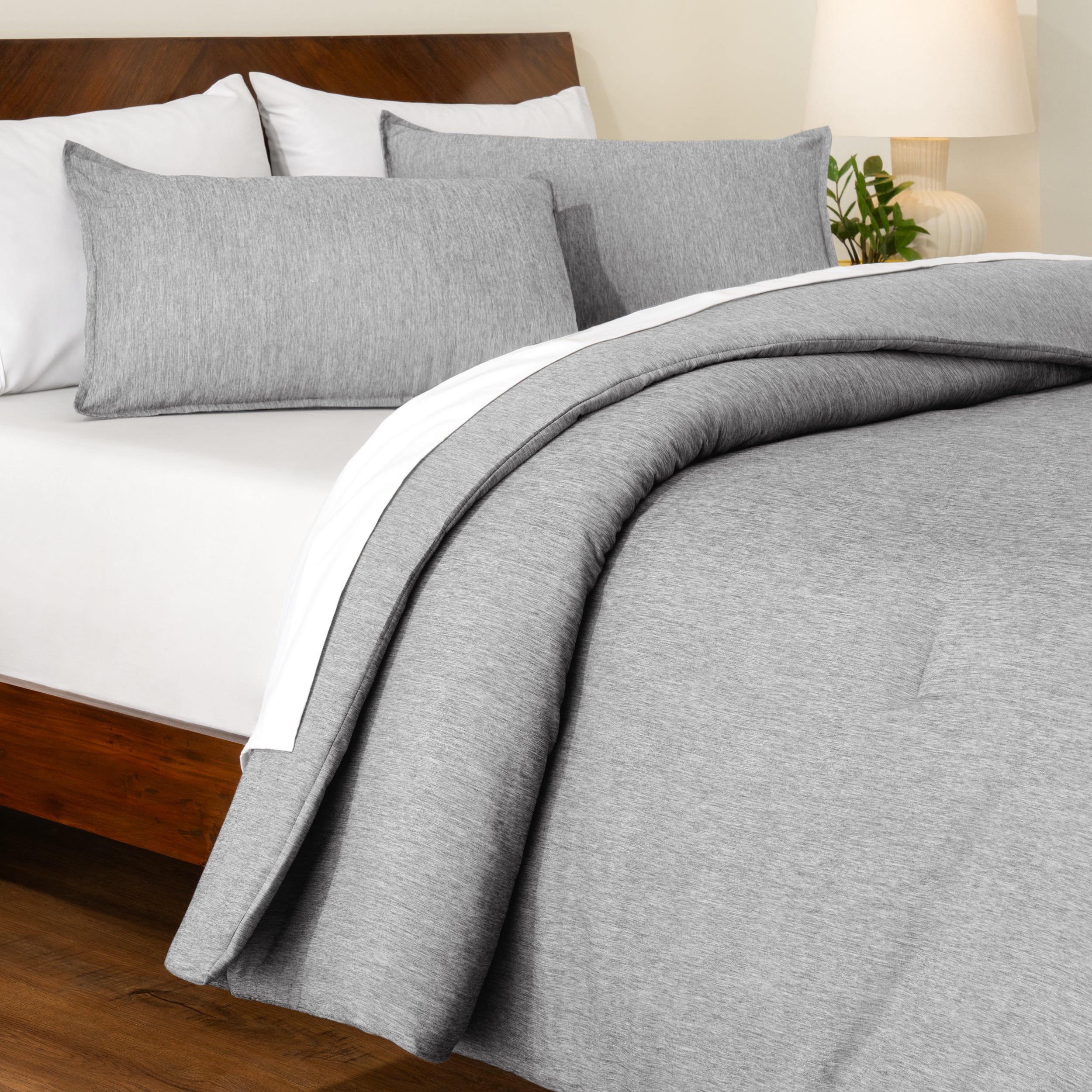 Track stitch comforter on a bed with white pillows and a wooden headboard.
