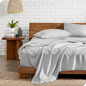 Microfiber sheets on a bed with a wooden headboard