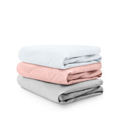 Stack of folded crib sheets on a white background