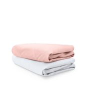 Stack of folded crib sheets on a white background