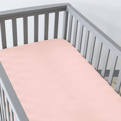 Gray crib with a fitted sheet on the mattress