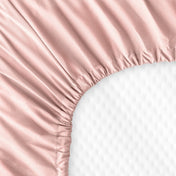 The back of a crib mattress with a fitted sheet on it