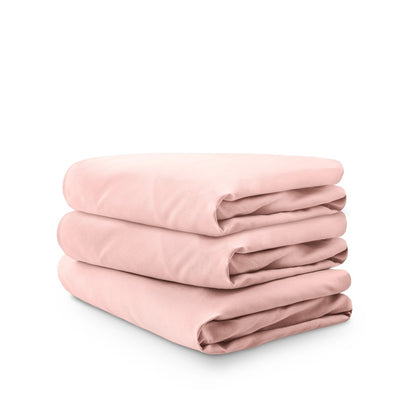 Stack of pink folded crib sheets on a white background