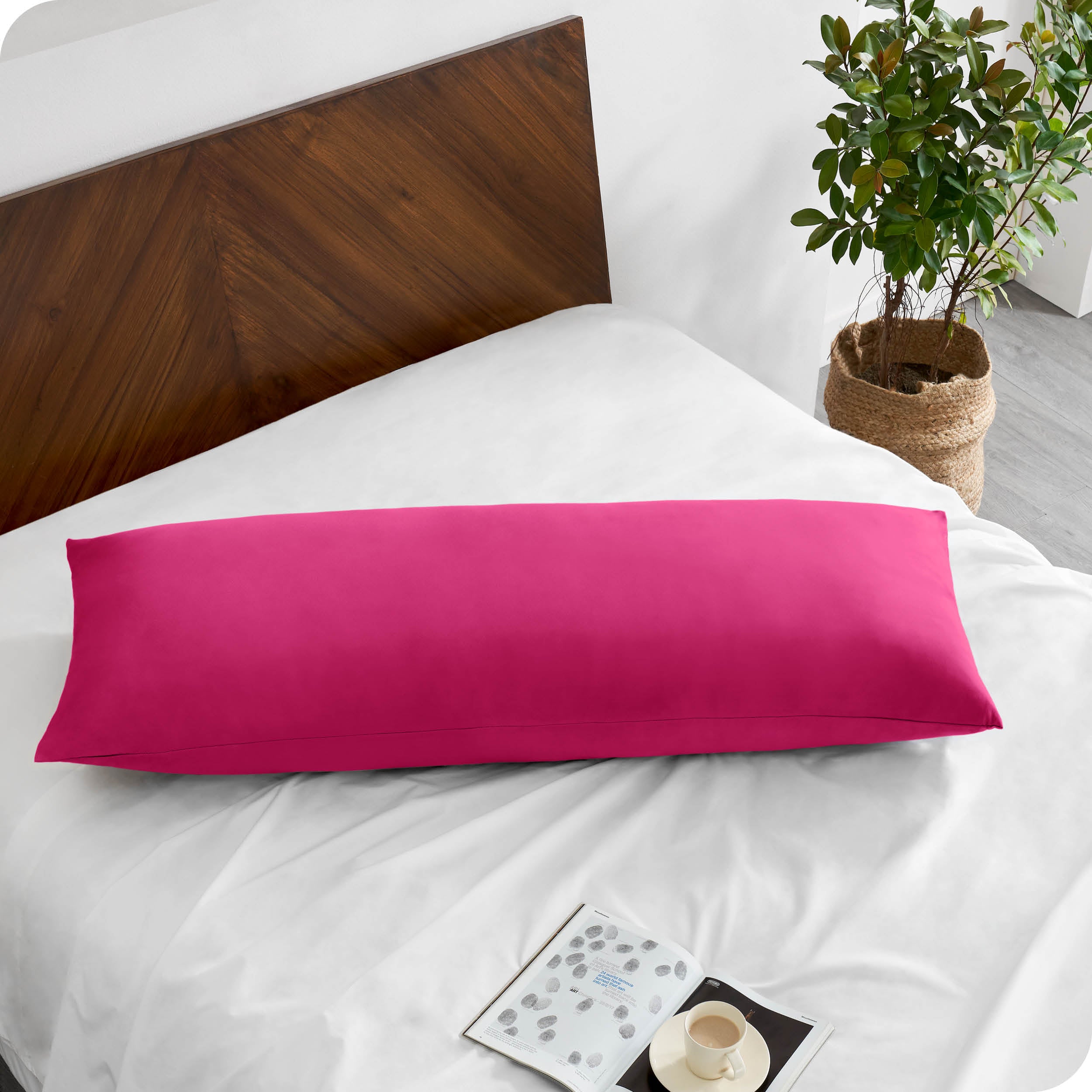 A body pillow cover on a pillow on a bed made with all white bedding