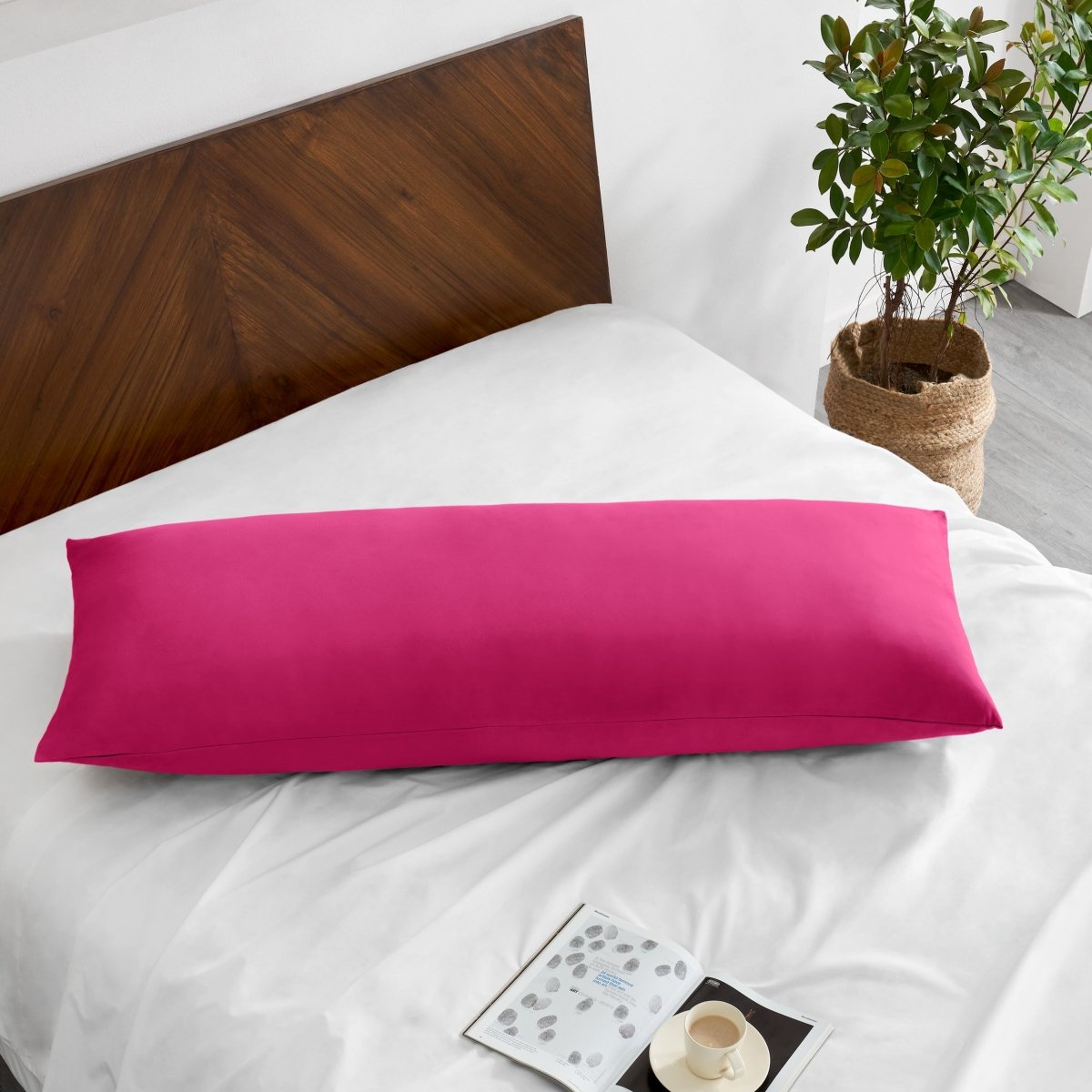 Pillowcase on a body pillow with a wooden headboard and plant in the background