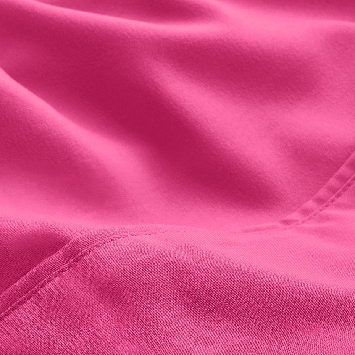 A close-up of microfiber fabric with soft folds and a visible stitched seam.