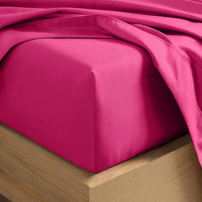 A close-up of a fitted sheet covering the corner of a bed frame, with matching top sheet draped over it.