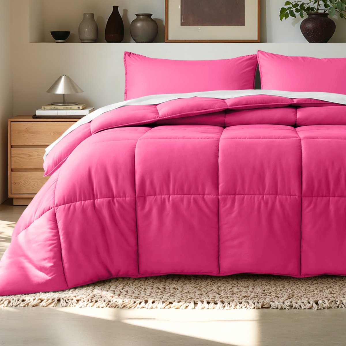 Comforter on a bed in a bedroom setting with a wooden nightstand and decorative items.