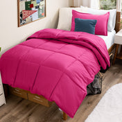 Bed with comforter and pillows in a dorm room
