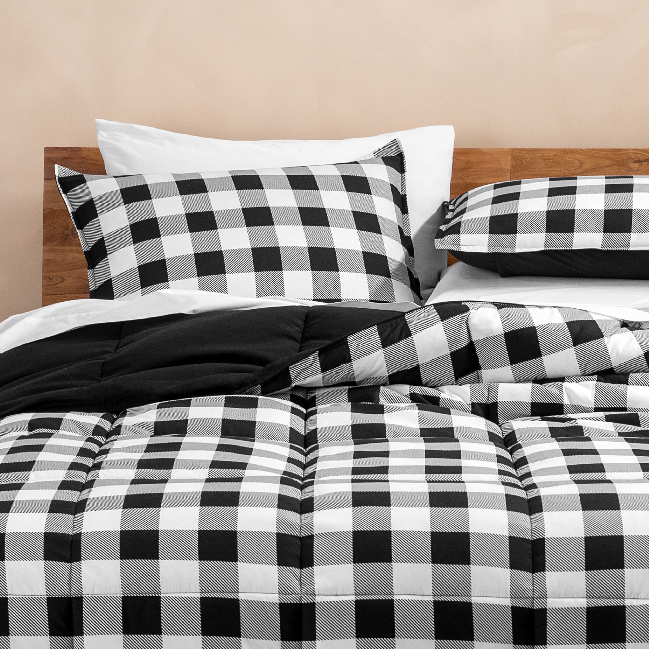 Black and white checkered bedding set on a bed with pillows.