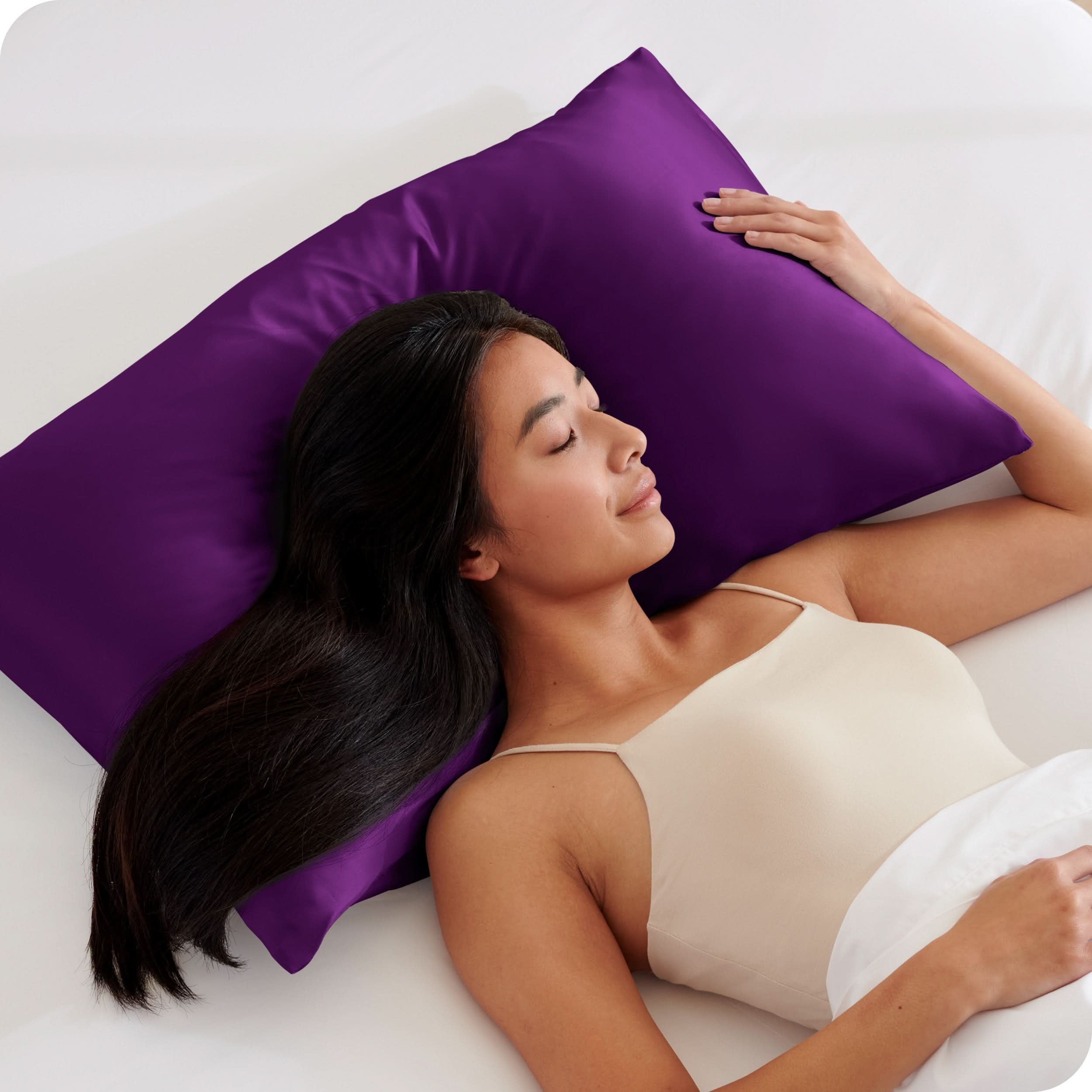 A woman is sleeping with her head on a silk pillowcase