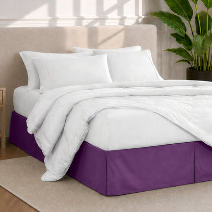 A modern bedroom with a bed skirt, comforter and sheets on the bed