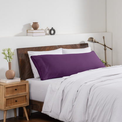 Bedroom with a wooden headboard and white bedding, featuring a nightstand and decorative items.