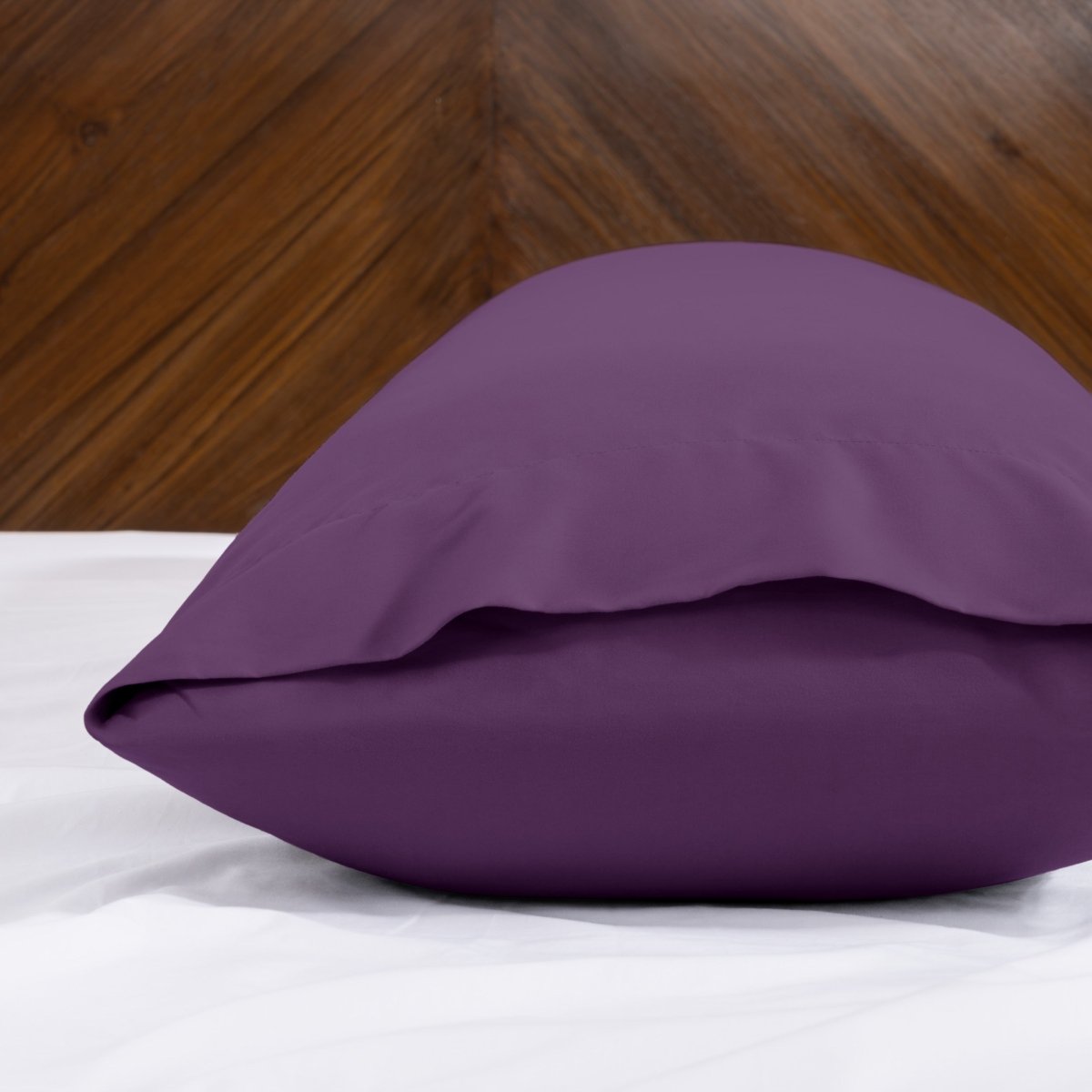 Body pillowcase with an envelope closure on a bed with a wooden headboard
