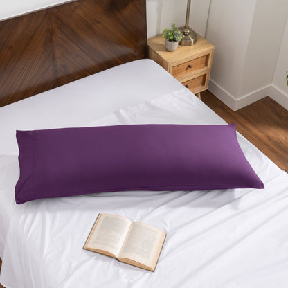 Pillowcase on a body pillow with a wooden headboard and plant in the background