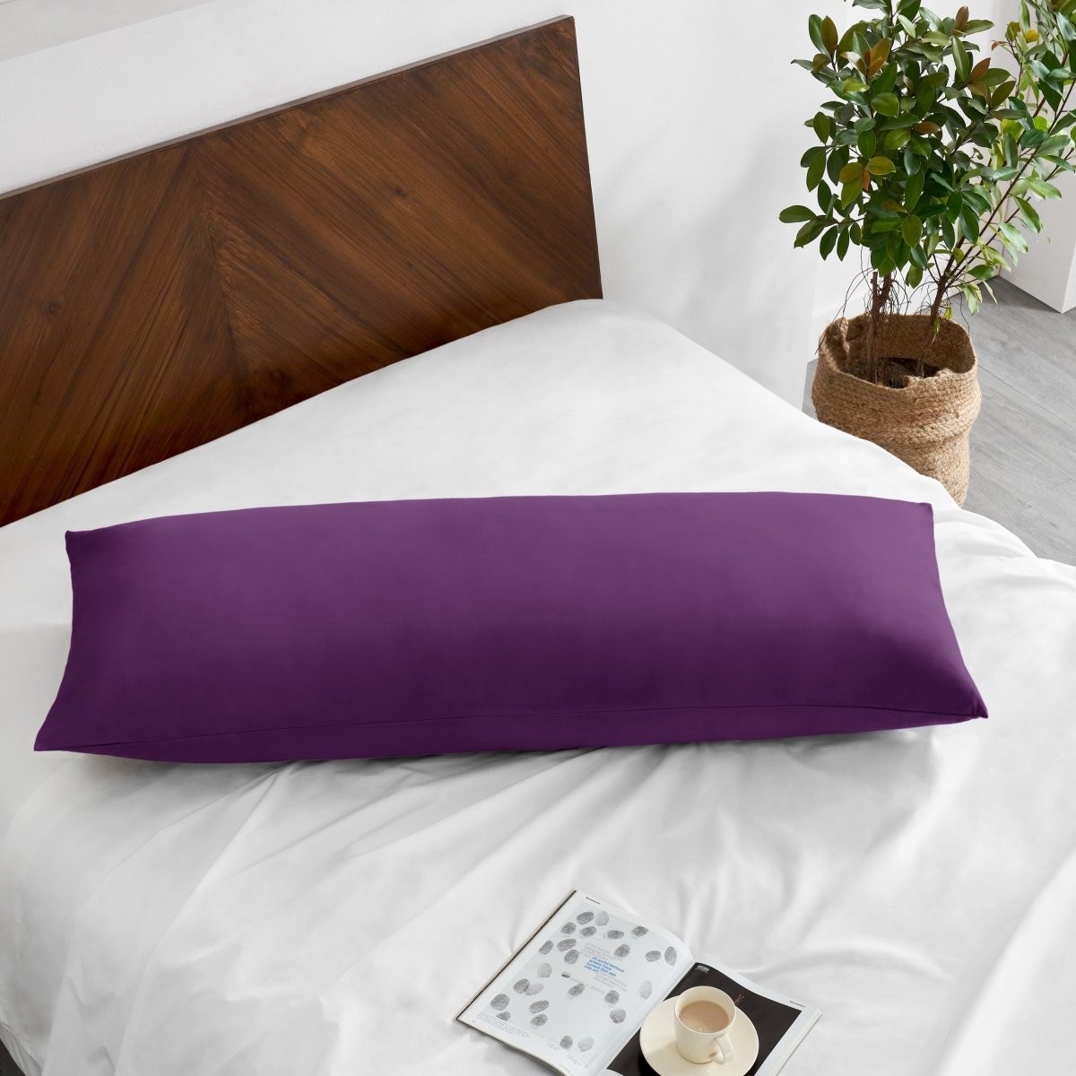Pillowcase on a body pillow with a wooden headboard and plant in the background