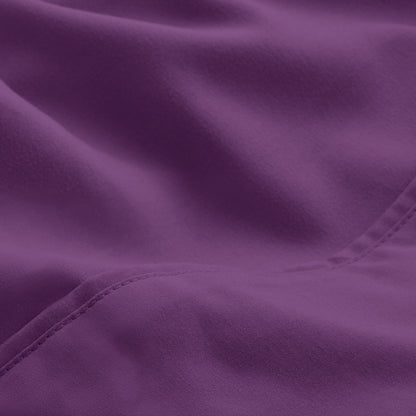 A close-up of microfiber fabric with soft folds and a visible stitched seam.