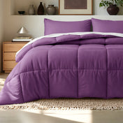 Comforter on a bed in a bedroom setting with a wooden nightstand and decorative items.