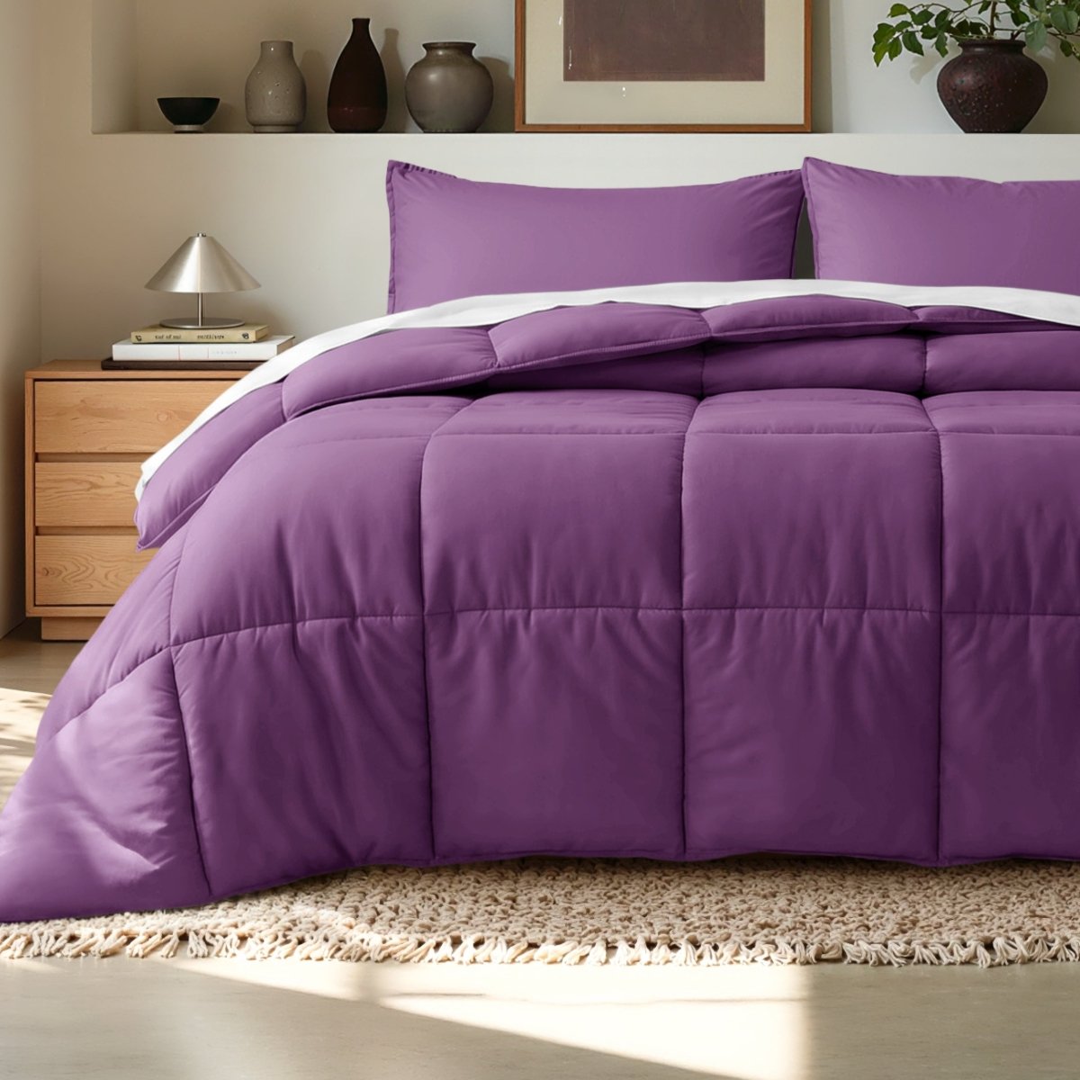 Comforter on a bed in a bedroom setting with a wooden nightstand and decorative items.