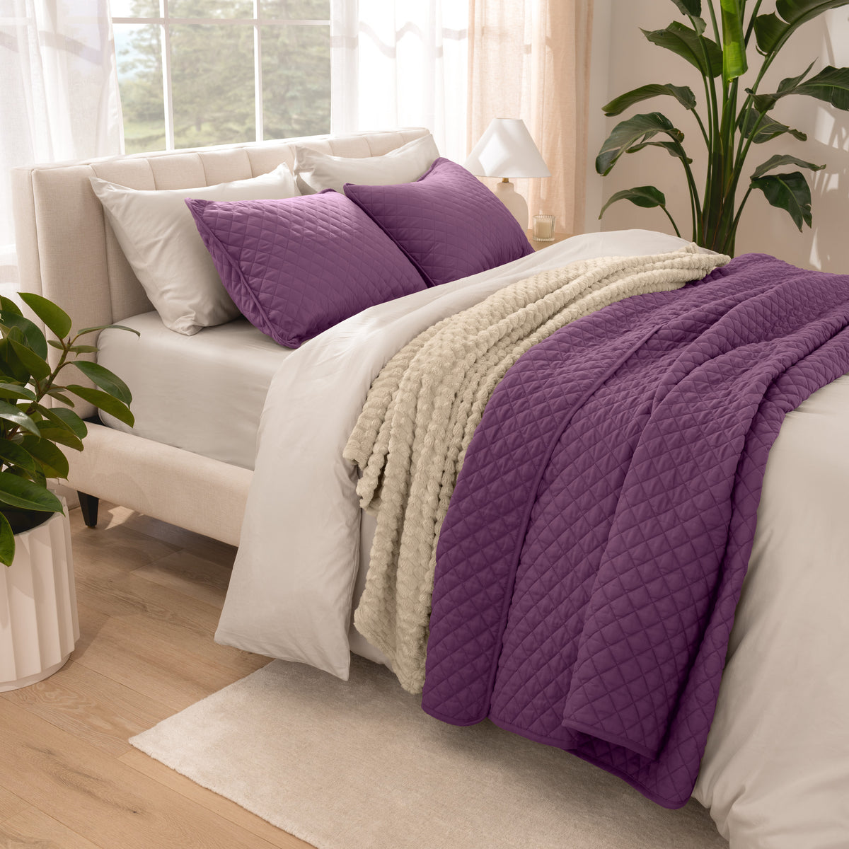Side view of bed with coverlet set draped on a bed made with a duvet set