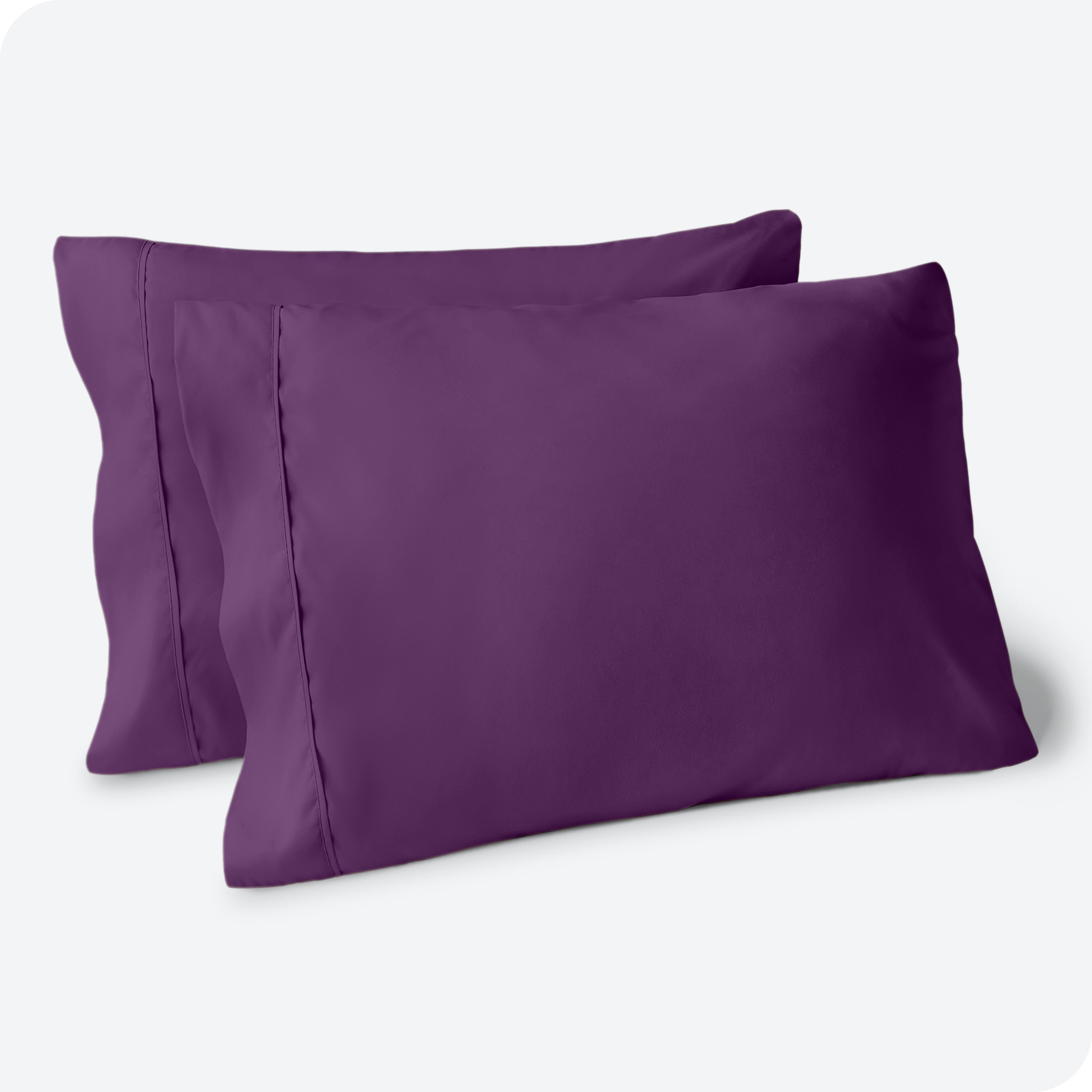 Two pillows on a white background with purple pillowcases on them