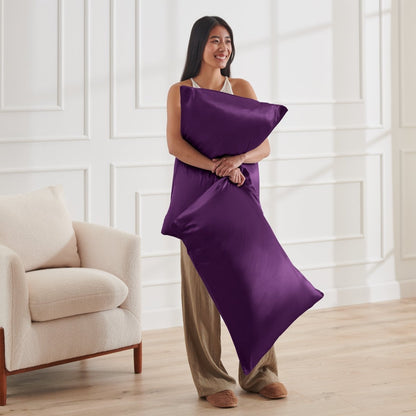 Woman holding 2 pillows with satin pillowcases on them