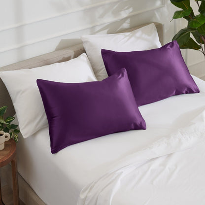 Satin pillowcases on a bed with white bedding