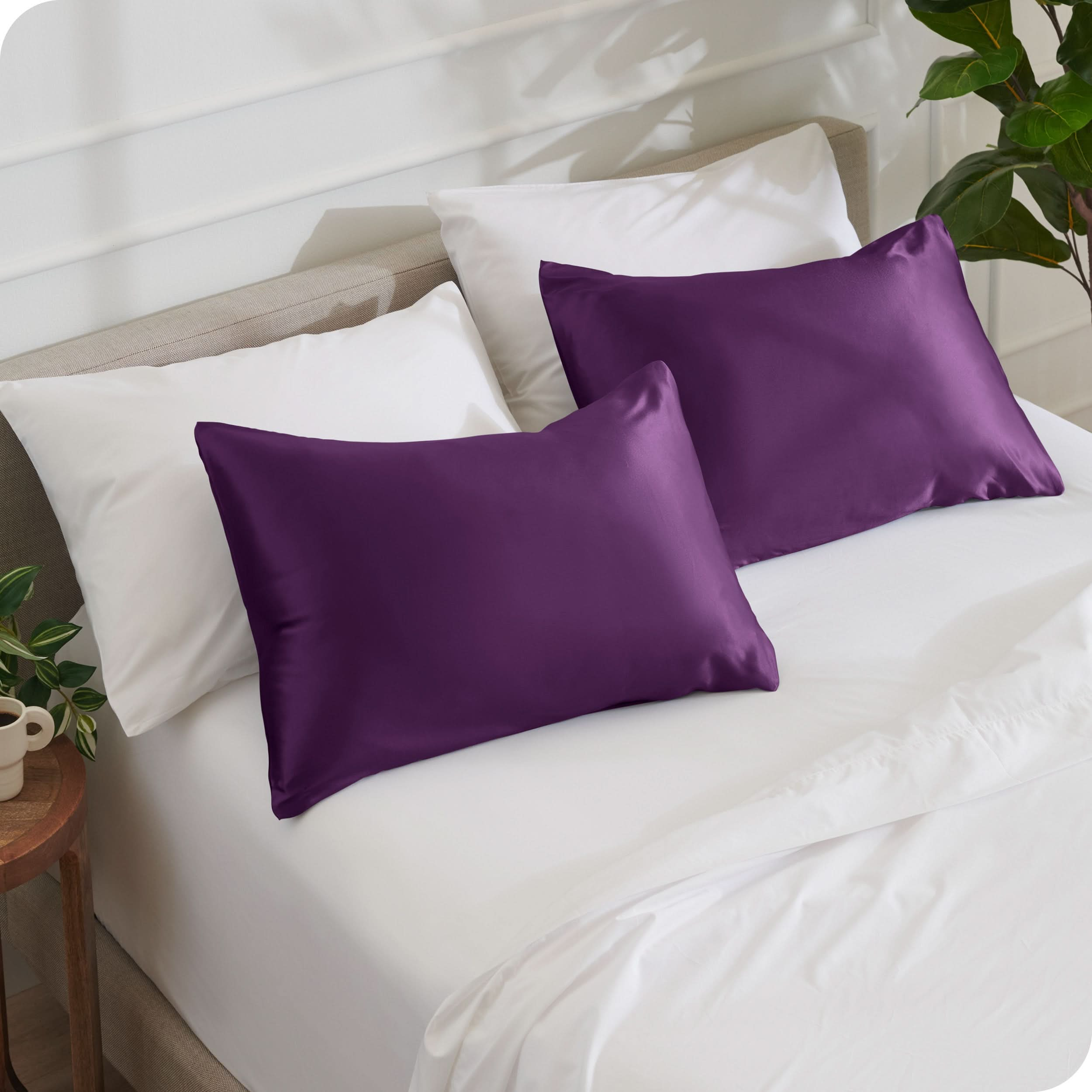 2 satin pillowcases on pillows set on a bed