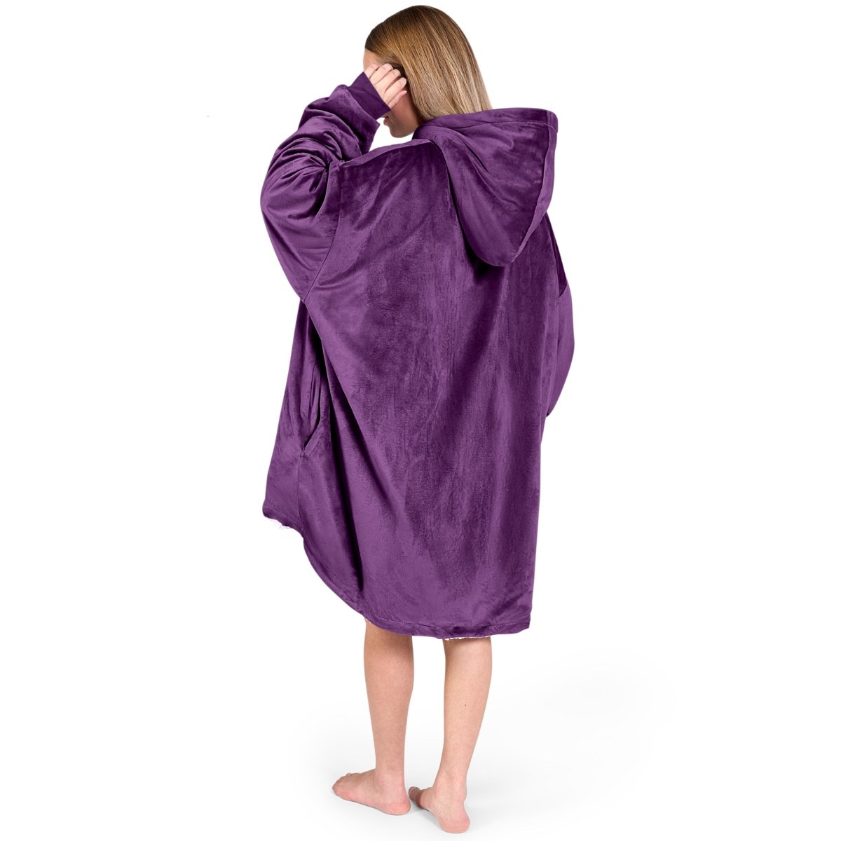 An adult with a hooded wearable blanket on