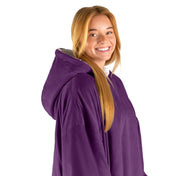 An adult with a hooded wearable blanket on
