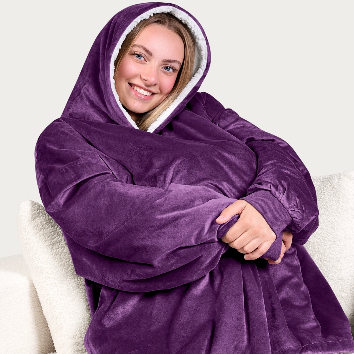 An adult with a hooded wearable blanket on